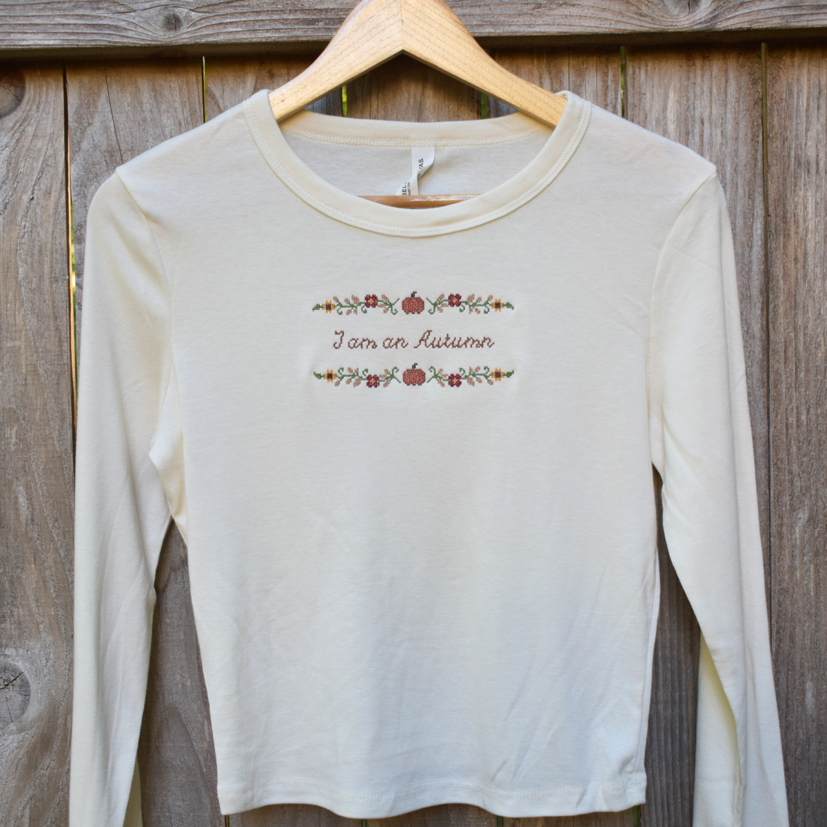 I am an Autumn — Embroidered Bella + Canvas Long Sleeve Baby Tee